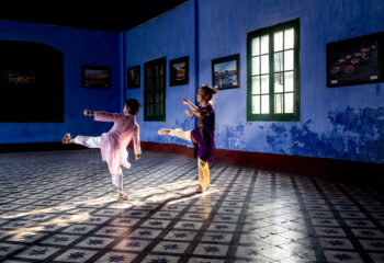 Two dancers in a blue room with a Vietnamese ambience.