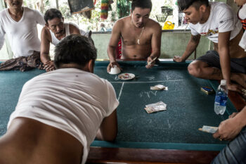 A group of men playing a game of poker in Vietnam.