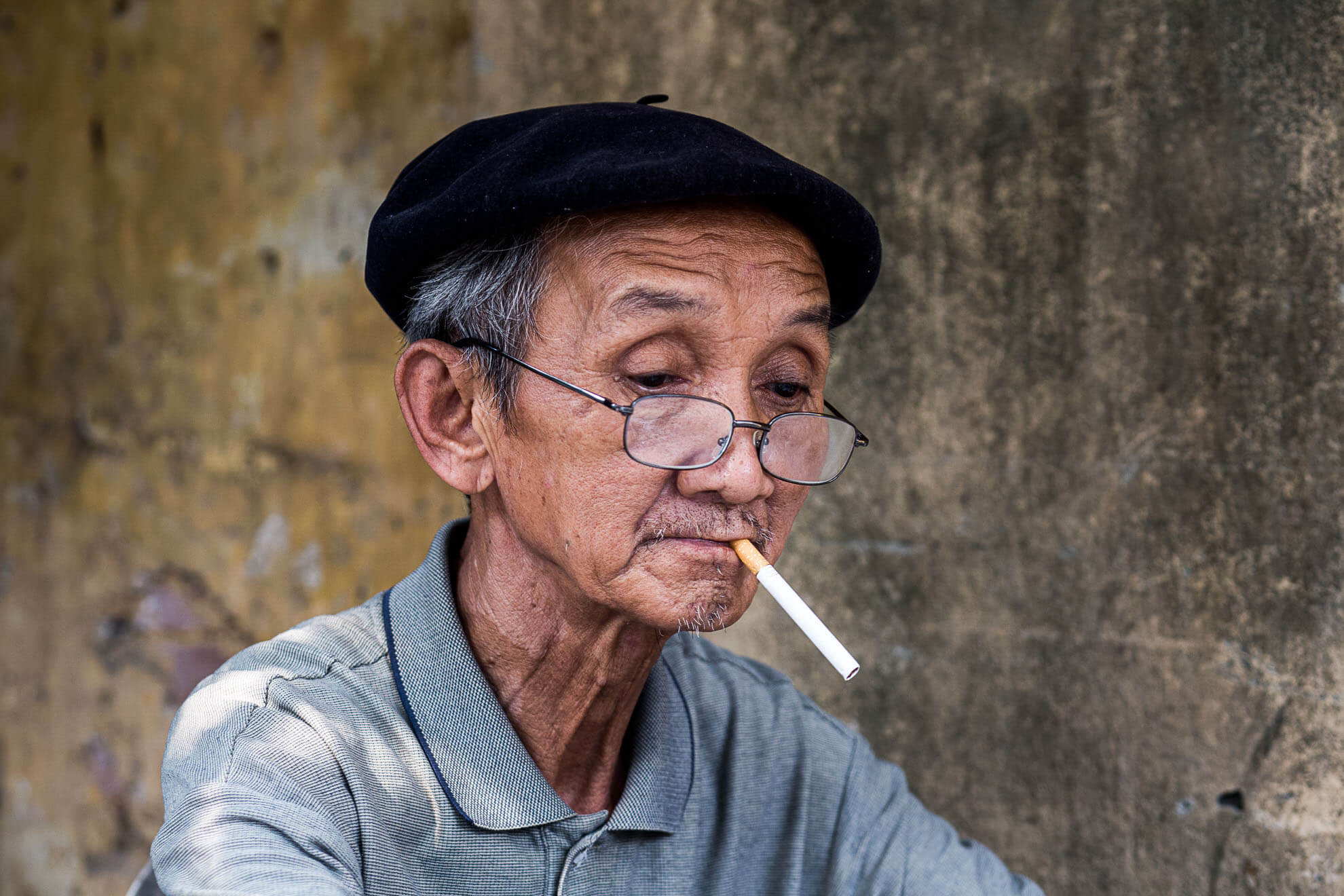 Ein alter Mann raucht in Vietnam eine Zigarette.