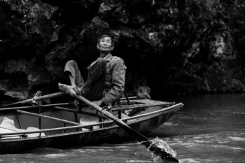 A man in a canoe on a river in Vietnam.