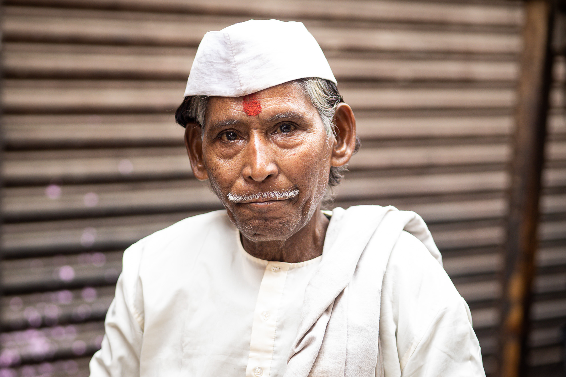 Un homme indien portant un chapeau blanc.