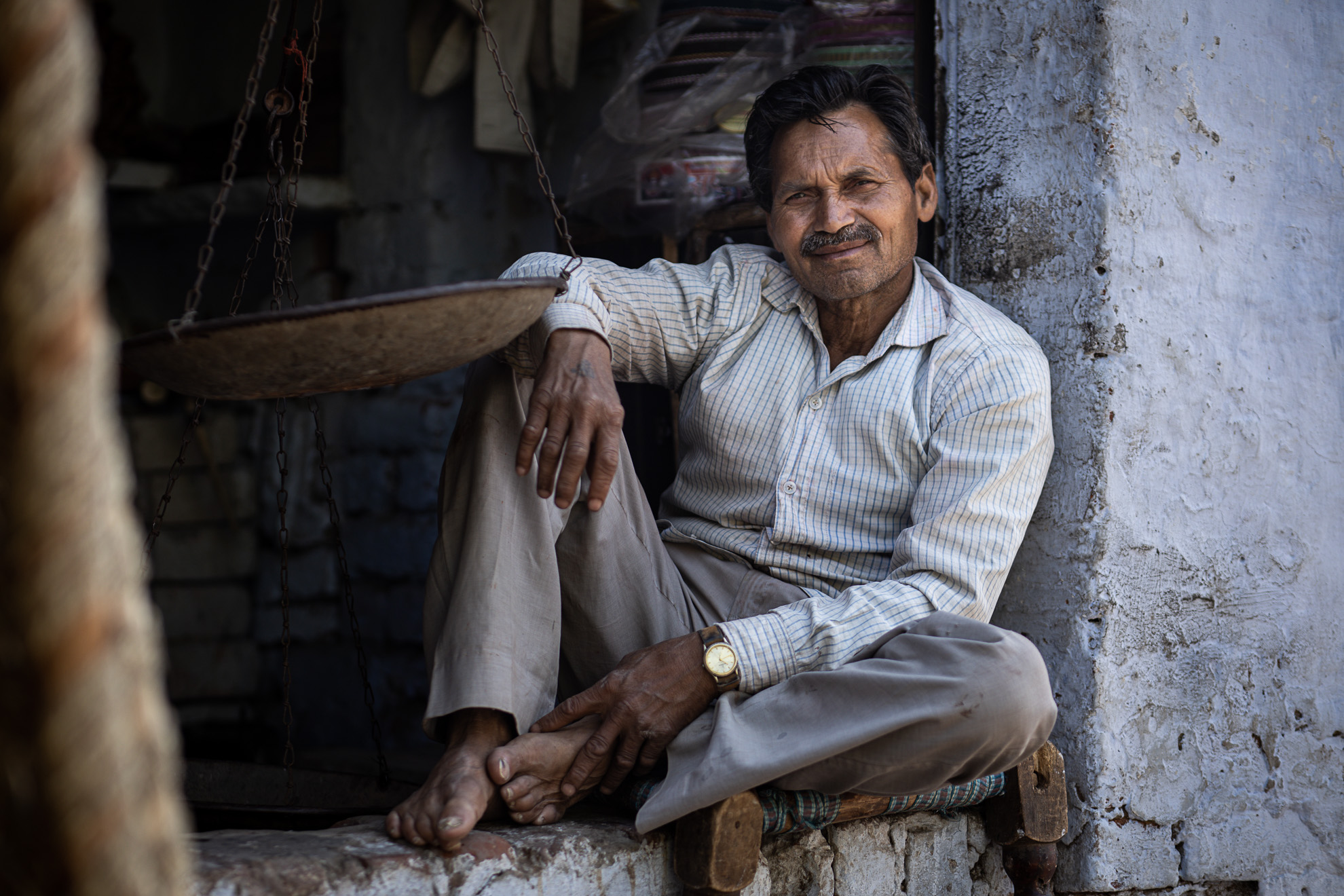 Un Indien assis sur les marches d’un immeuble en Inde.