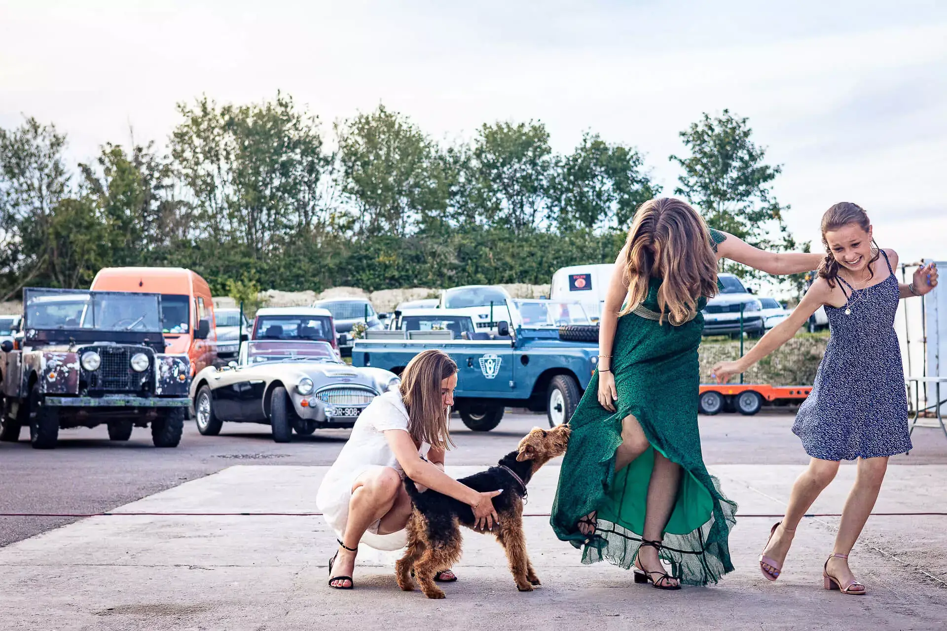 Un chien s'ammusant à mordre la robe des filles.