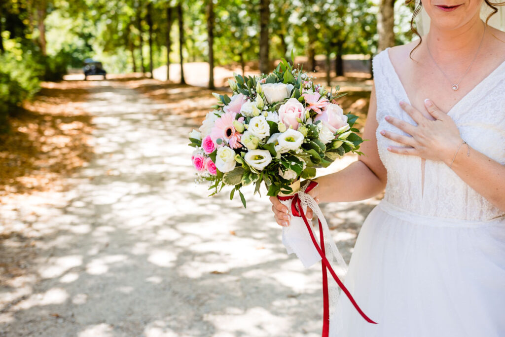 La mariée a son bouquet à la main.