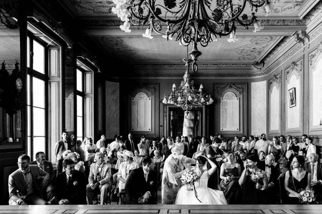 La tante de la mariée repositionne son voile dans la mairie.