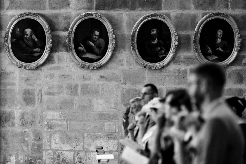 Portraits peints au mur de la Cathédrale de Langres, derrière le premier rang des invités du mariage.