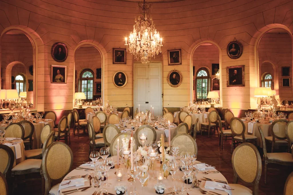 Une réception de mariage dans une salle ornée de lustres.