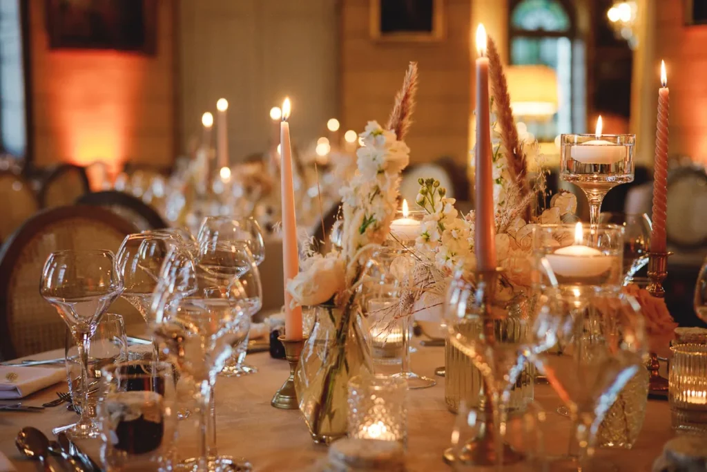 Une table dressée avec des bougies et des fleurs.