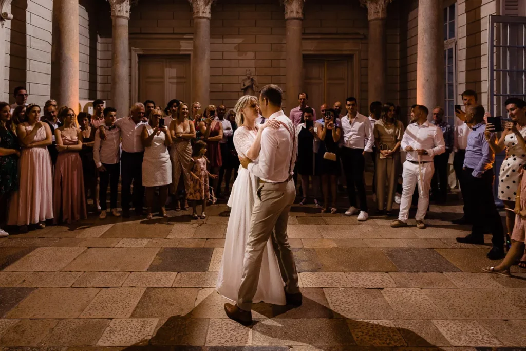 Les mariés partagent leur première danse devant une foule.