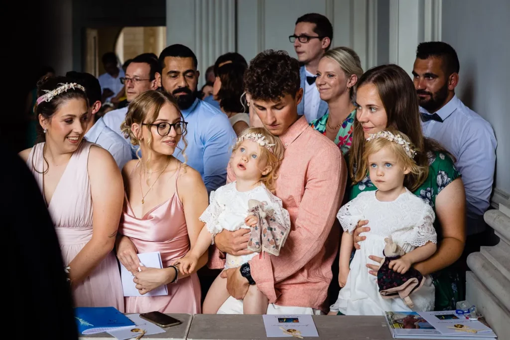 Un groupe de personnes lors d’un mariage avec un bébé dans les bras.