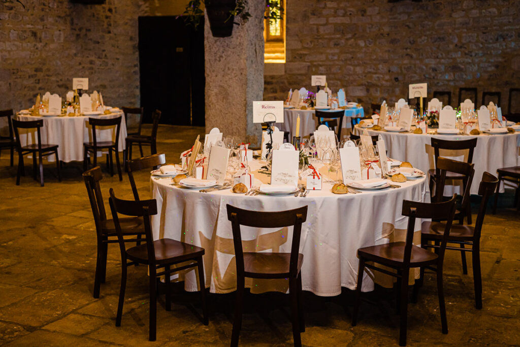 Une salle avec tables et chaises aménagées pour une fête.