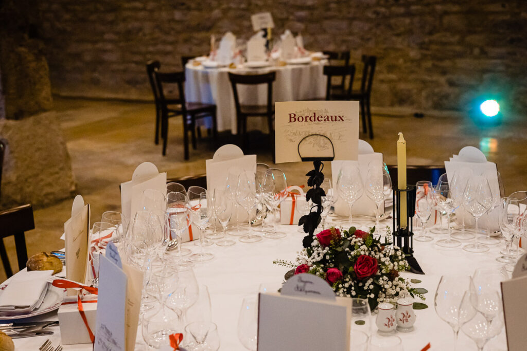 Une table dressée pour une réception de mariage dans un bâtiment en pierre.