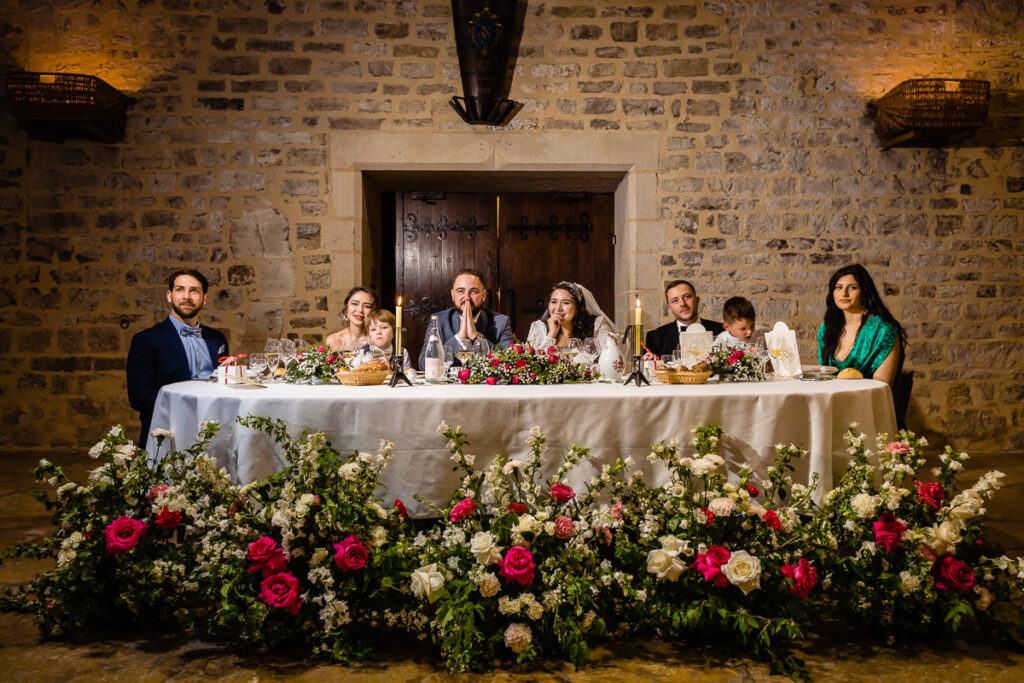 Un groupe de personnes assises autour d’une table dans un bâtiment en pierre.