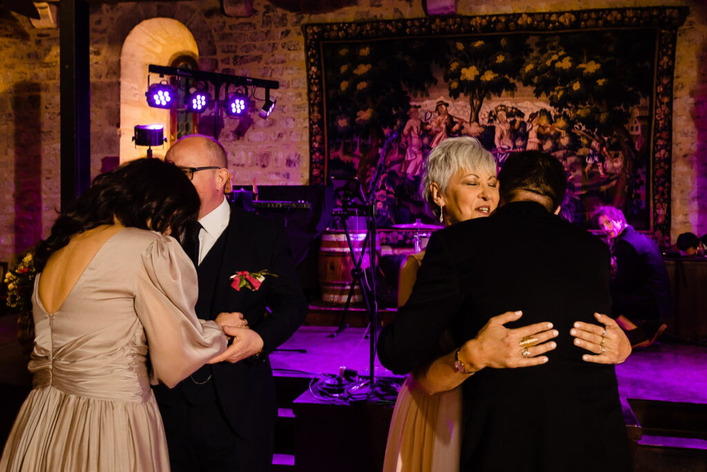 Un groupe de personnes s’embrassant lors d’une réception de mariage.