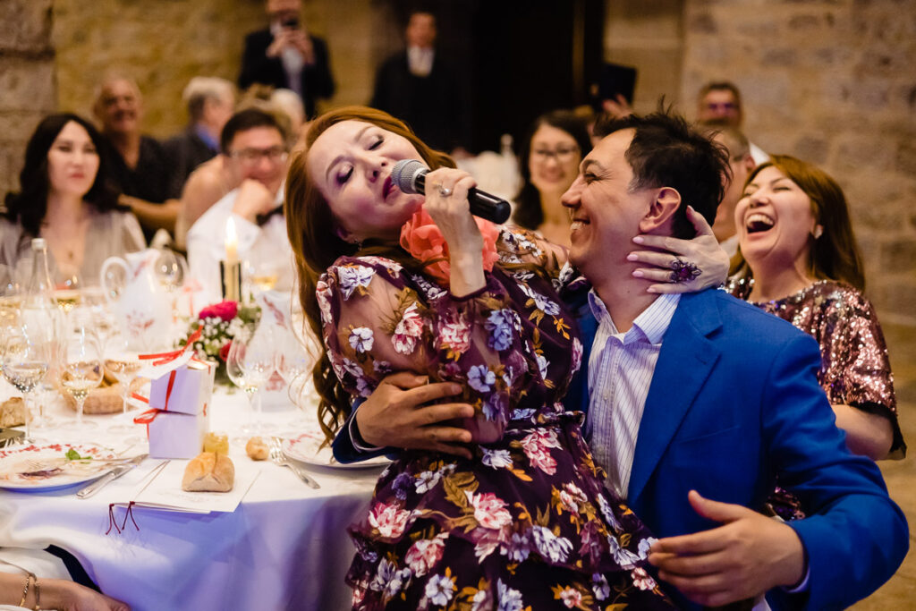 Un homme chante dans un microphone lors d’une réception de mariage.