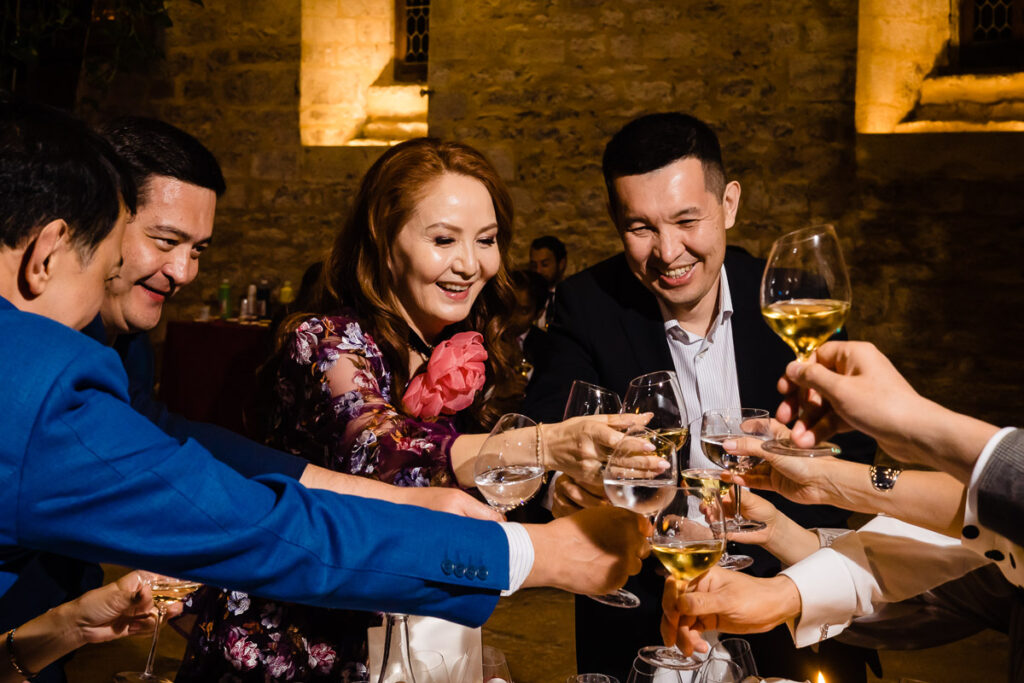 Un groupe de personnes trinquant du vin à une table.