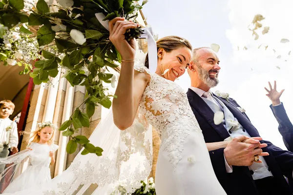 Un couple de marié sortant de l'église est heureux de son choix de photographe de mariage.