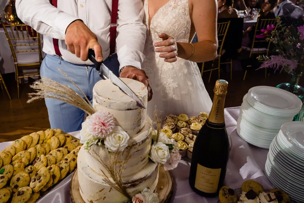 Des mariés coupant un gâteau de mariage.