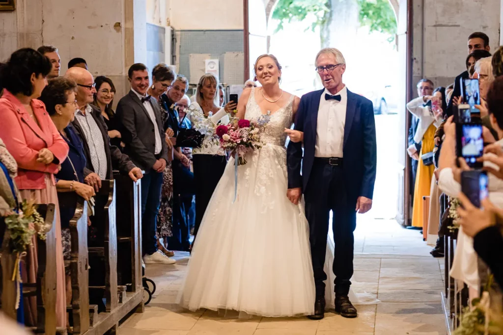 Des mariés marchant dans l’allée d’une église.