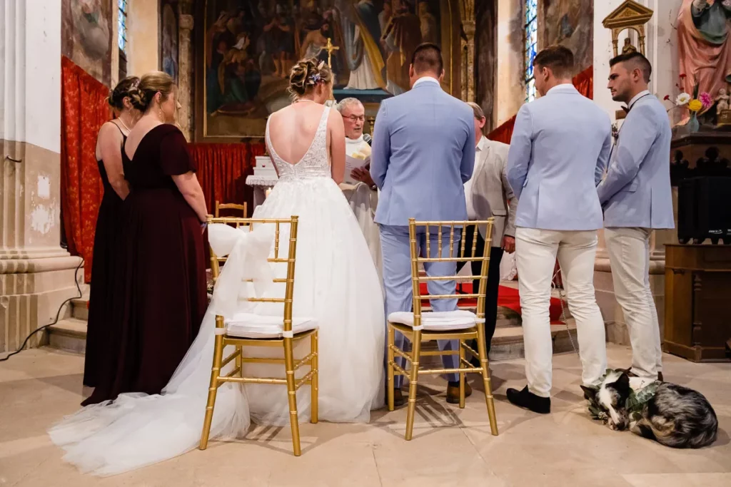 Une cérémonie de mariage dans une église avec un chien en arrière-plan.