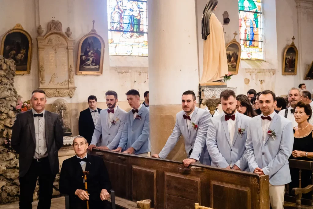 Un groupe de garçons d’honneur debout dans une église.