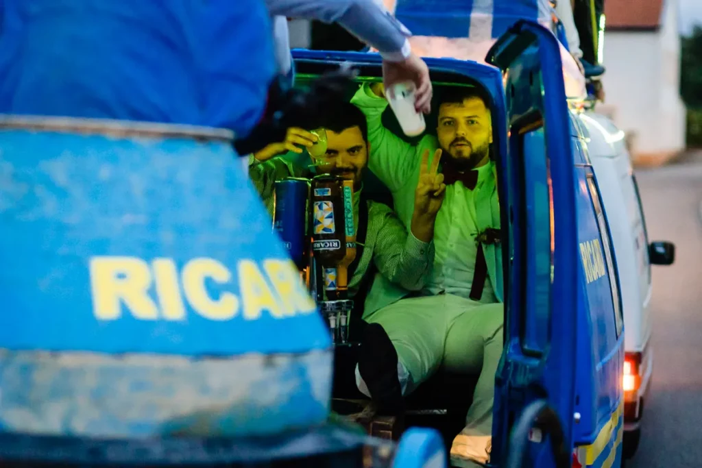 Un groupe d’hommes est assis à l’arrière d’un camion bleu.