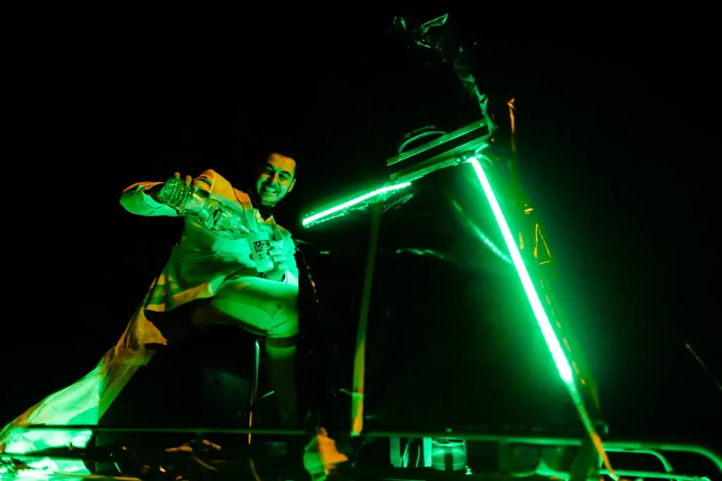 Un homme en costume vert tient un feu vert.