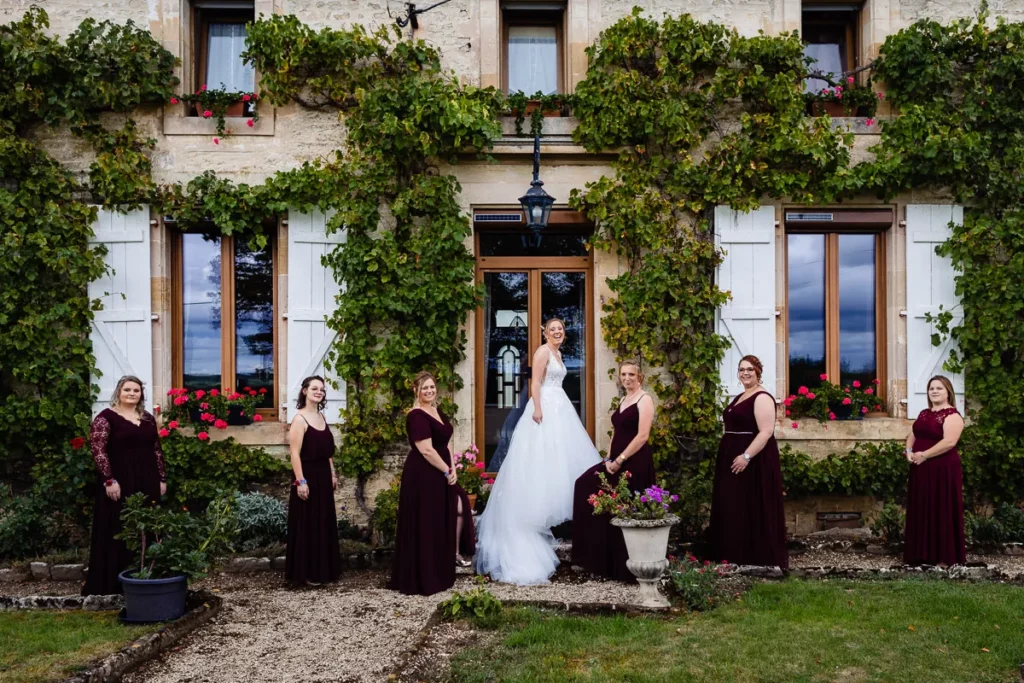 Mariée et demoiselles d'honneur posant devant une maison.