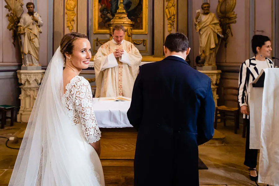 Des mariés se regardent dans une église.