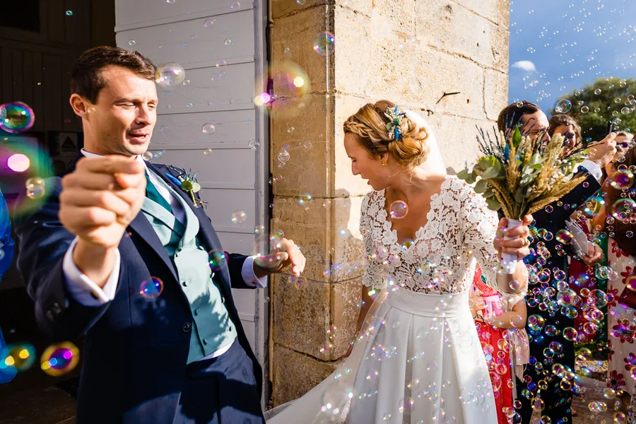 Des mariés font des bulles lors de leur mariage.