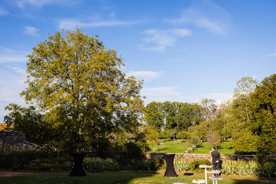 Une cérémonie de mariage dans un jardin avec des arbres en arrière-plan.