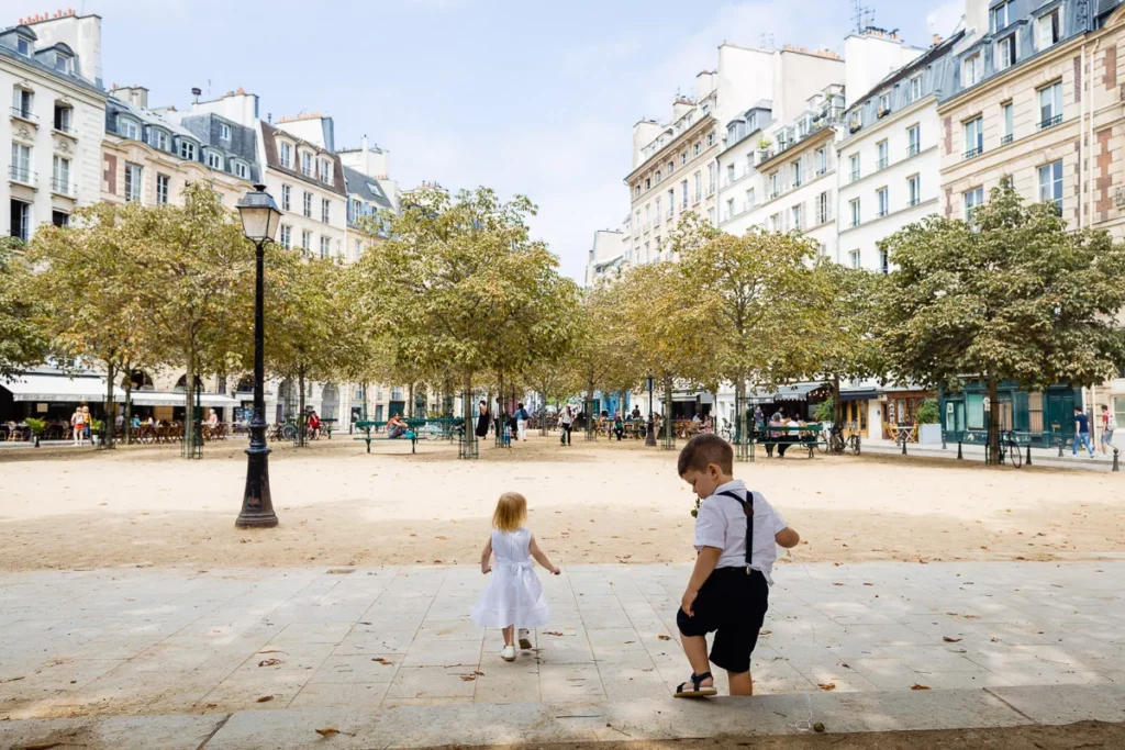 Deux enfants marchant sur une place à Paris.