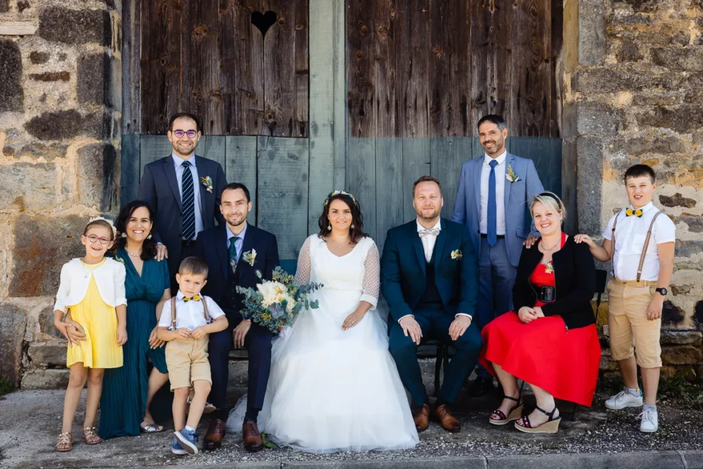 Une fête de mariage posant devant une porte en bois.