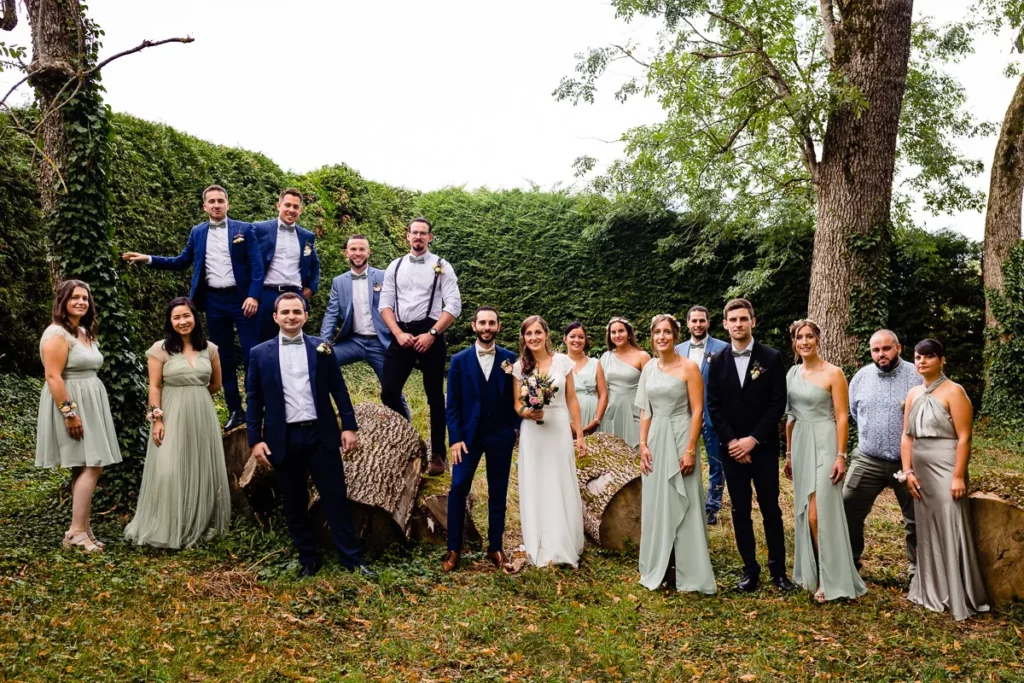 Un groupe de demoiselles d’honneur et de garçons d’honneur posant pour une photo dans les bois.