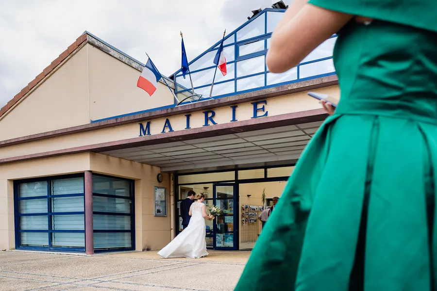 Une mariée et un marié debout devant un immeuble.