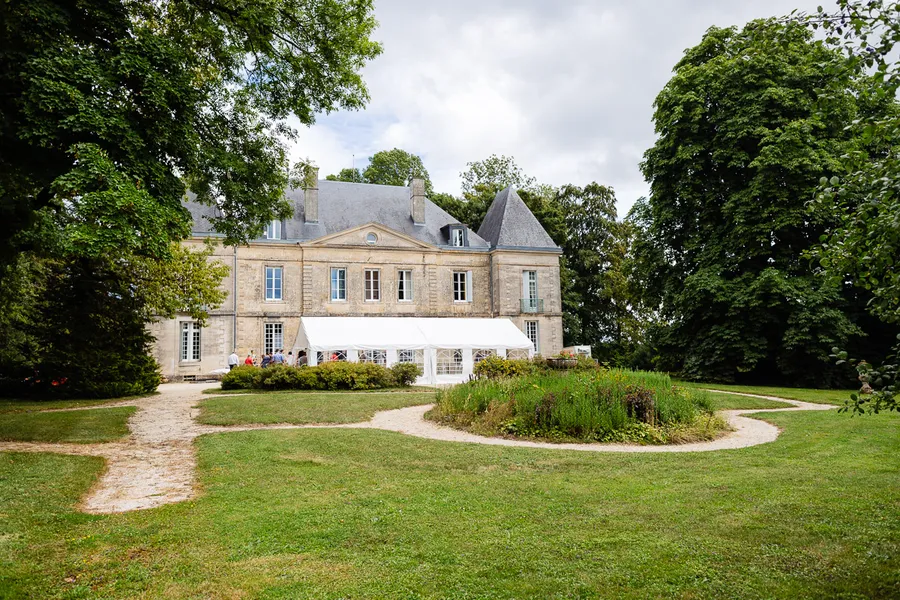 Un grand manoir au milieu d'un champ verdoyant.