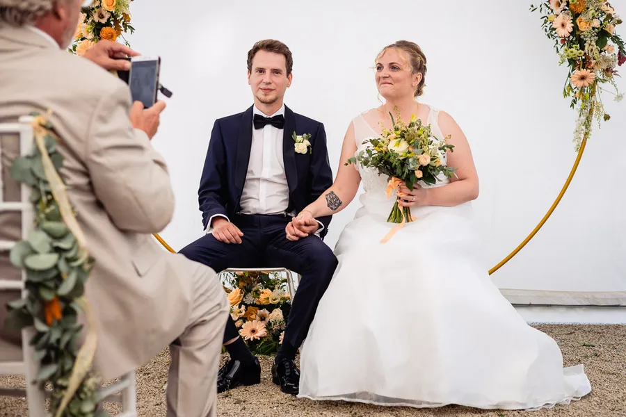 Les mariés prennent une photo lors de leur cérémonie de mariage.