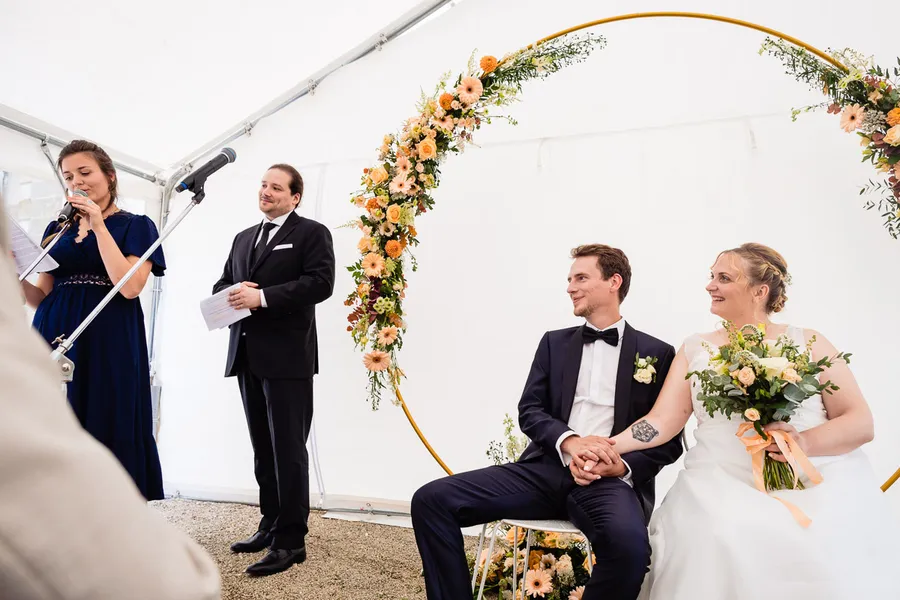 Une cérémonie de mariage sous tente avec les mariés.