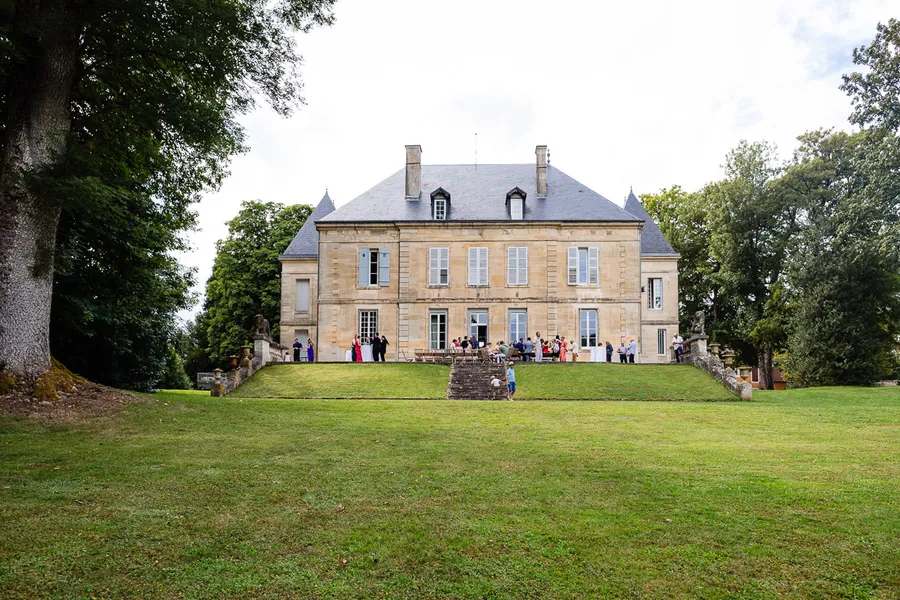 Un grand manoir au milieu d'un champ herbeux.