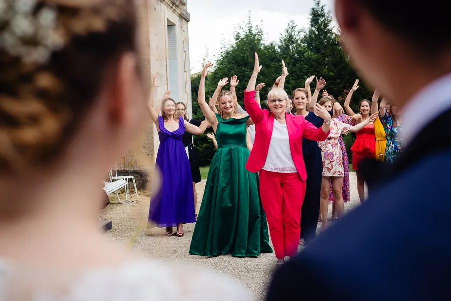 Un groupe de mariés dansant les mains en l’air.