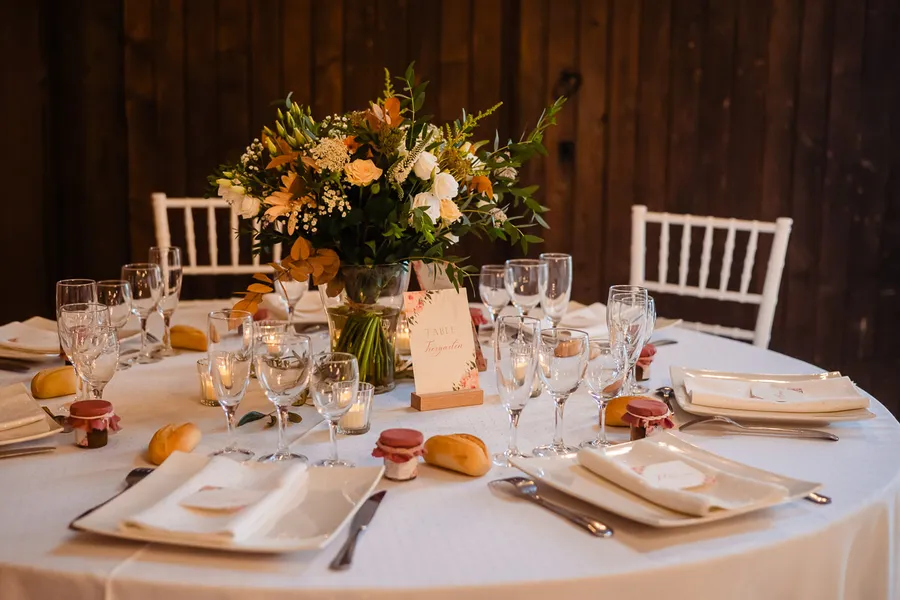 Une table avec des assiettes et des serviettes blanches sur une table en bois.